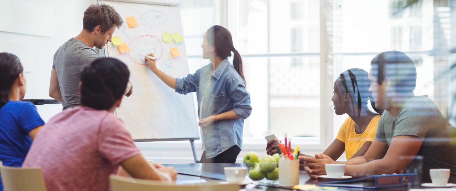 Business executives discussing with their colleagues on whiteboard
